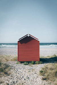 Hut on beach against sky