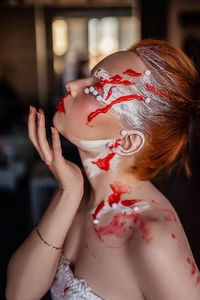 Portrait of a young girl in red and white paint