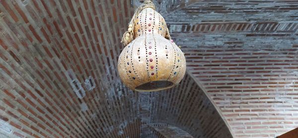 Low angle view of lighting equipment hanging on wall