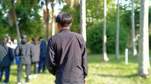 Rear view of man walking on field