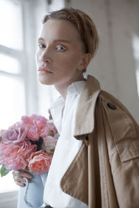 Portrait of fashionable woman with bouquet at home