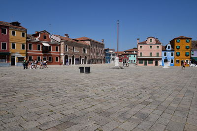 Buildings in town against clear blue sky
