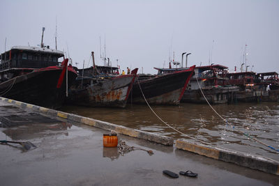 Fishing boats moored in sea against clear sky