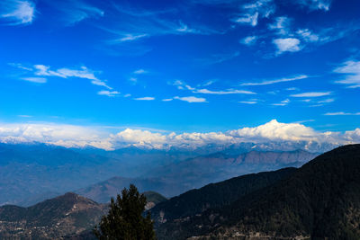 Scenic view of mountains against blue sky