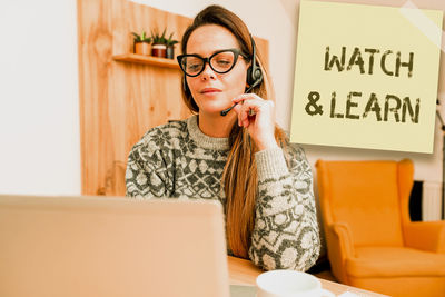 Midsection of woman using mobile phone while sitting on table