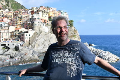 Portrait of smiling man standing against sea