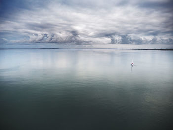 Scenic view of calm lake against cloudy sky