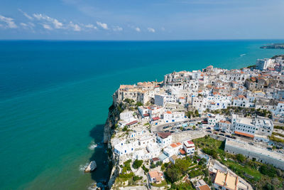 High angle view of townscape by sea against sky