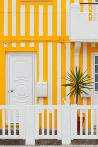 Typical colourful houses with yellow and white stripes in costa nova - aveiro against sky