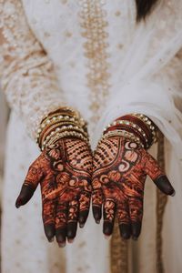 High angle view of woman showing henna tattoo on palm of hands