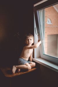 Full length of shirtless boy at home