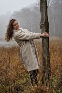 Side view of young woman standing on field