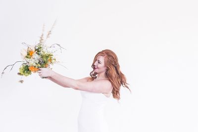 Beautiful happy woman holding bouquet against white background