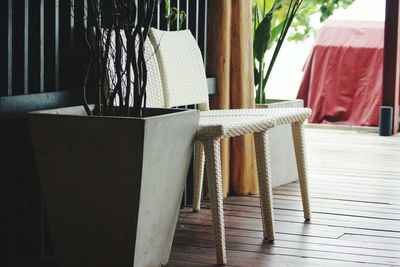 Close-up of empty chair by potted plant at home