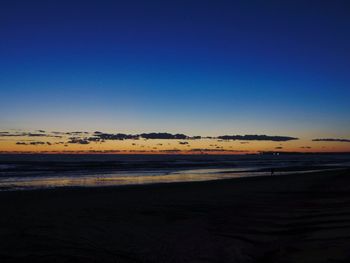 Scenic view of beach against clear blue sky