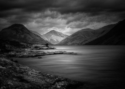 Scenic view of lake by mountains against sky