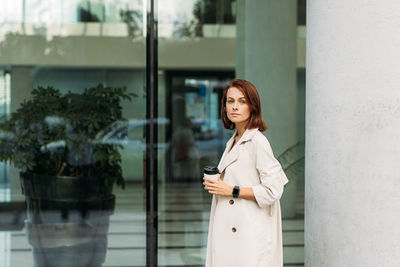 Young woman standing against wall