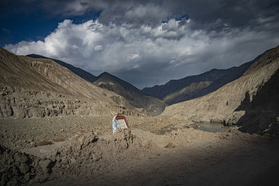 Rear view of person on arid landscape against sky