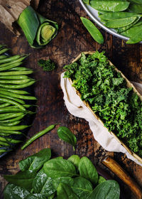 Selection of fresh green organic vegetables on a wooden table