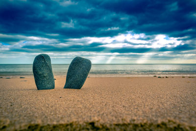 Deck chairs on beach against sky