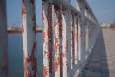 Close-up of rusty metallic railing against sky
