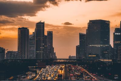Modern buildings in city against sky during sunset