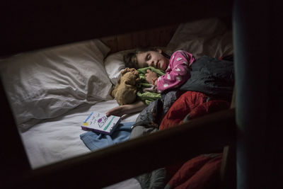 High angle view of cute girl sleeping on bed at home