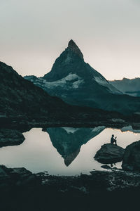 Scenic view of lake and mountain against clear sky during winter