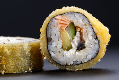 Close-up of sushi against black background