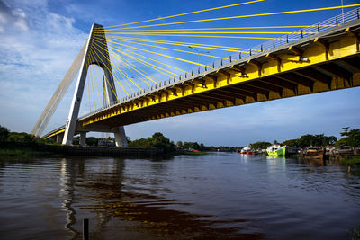 Low angle view of suspension bridge over river