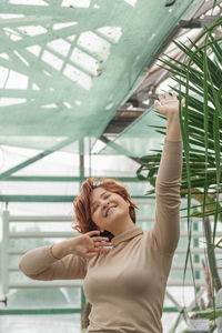 A beautiful plus size girl enjoying standing among the green plants