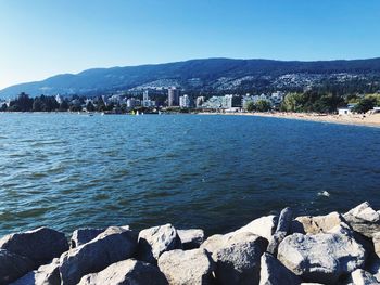 Scenic view of sea by buildings against clear sky