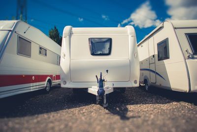 Tilt-shift image of white vehicle trailers against sky