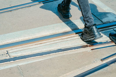 Low section of man walking on road