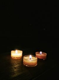 Close-up of illuminated tea light candles in the dark