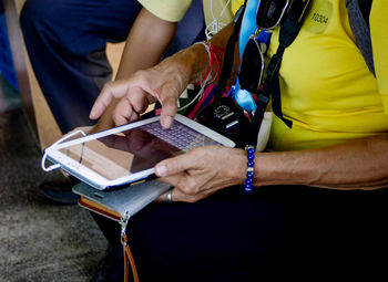 Midsection of man using mobile phone