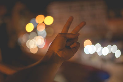 Midsection of person holding illuminated lighting equipment at night