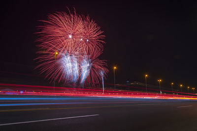 Light trails on road against sky at night