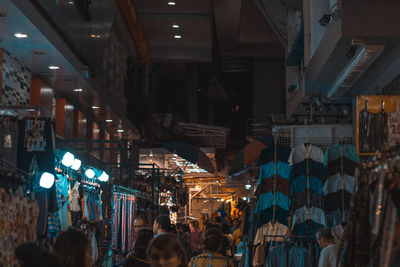 People at illuminated market in city at night