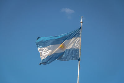 Low angle view of flag against clear blue sky