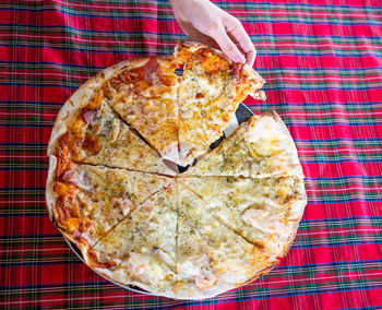 High angle view of hand holding pizza