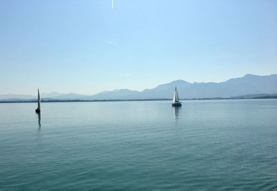 Sailboat in sea against clear sky