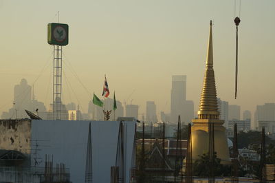 Flag in city against sky during sunset