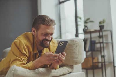 Young man using mobile phone at home