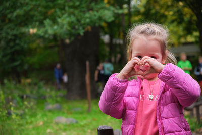 Portrait of young woman standing in park