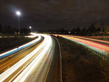 High angle view of light trails on street against sky at night