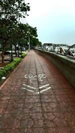 Surface level of footpath against sky in city