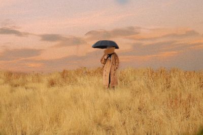 Woman standing on field against sky