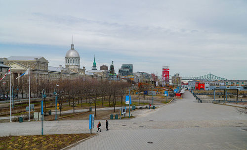 Buildings in city against cloudy sky