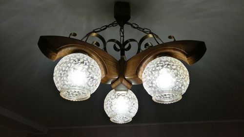 Low angle view of illuminated lamp hanging from ceiling in room